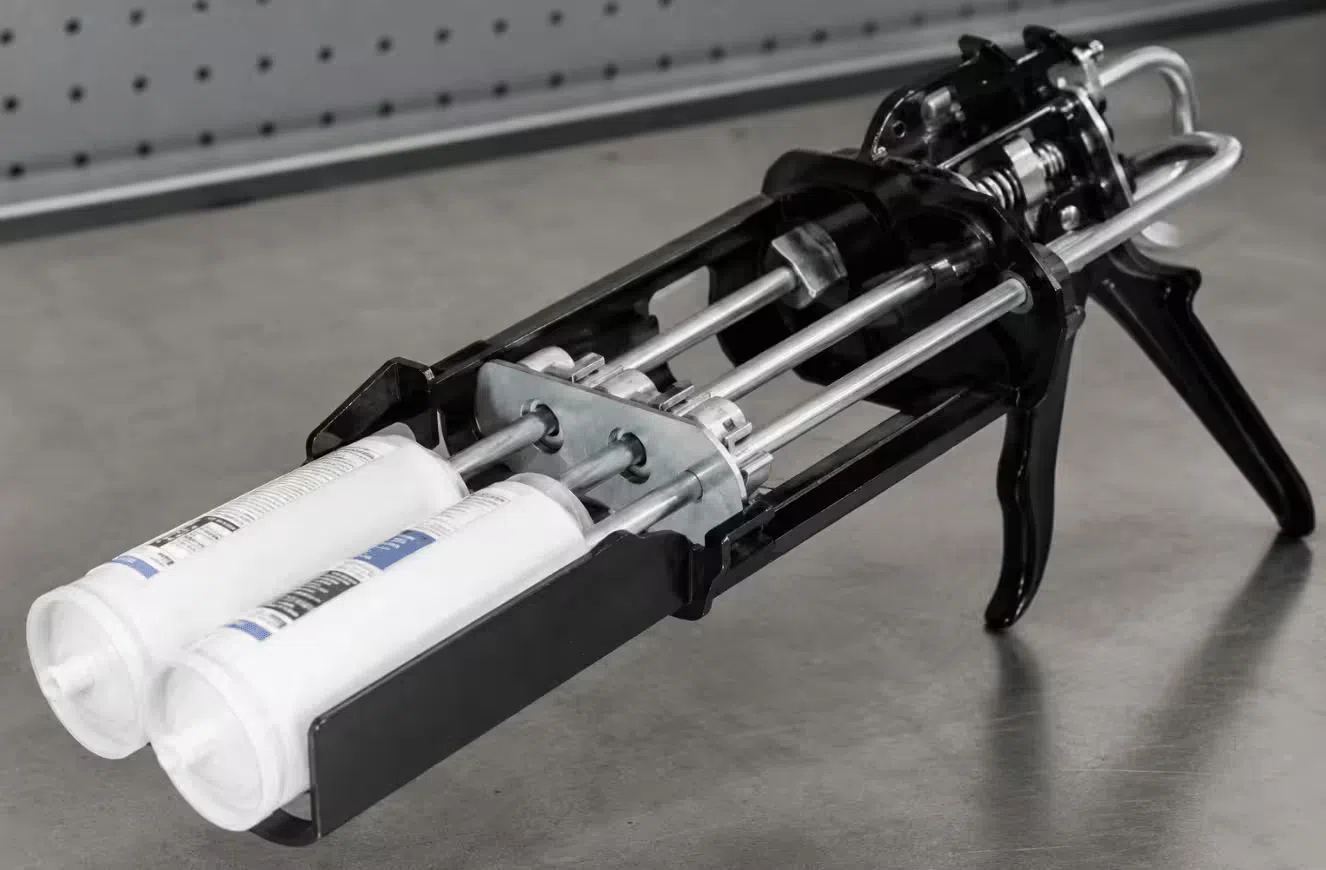 Paired push rods in a double barrel caulk gun with matched catch plates pressing against dual cartridge pistons